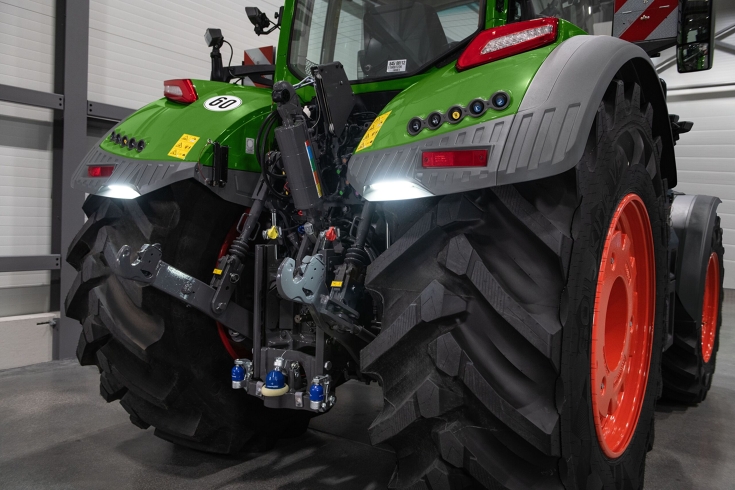 Fendt 800 Vario mit GroundVison Das Heck eines grünen Fendt 800 Vario in einer Halle fotografiert, die Deichselbeleuchtung GroundVision an den Kotflügeln ist eingeschaltet.