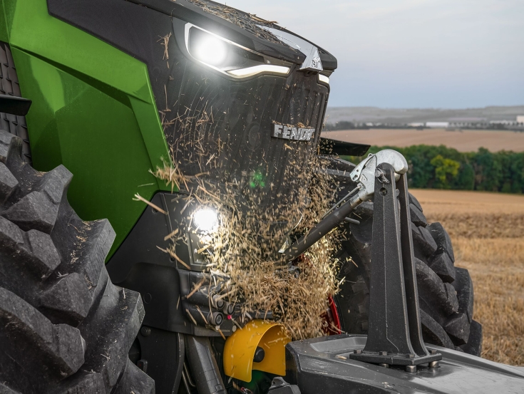 Umkehrlüfter für den Fendt 800 Vario Die Front eines grünen Fendt 800 Vario Traktors mit eingeschalteten Leuchten mit Stroh vor dem Kühlergitter, dass vom Umkehrlüfter weggeblasen wird.