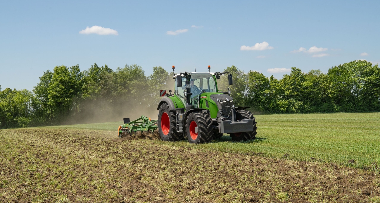 Ein grüner Fendt 724 Vario Gen7.1 grubbert mit einem Amazone Grubber ein Feld.
