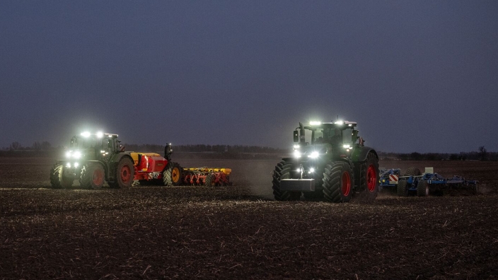 Ein grüner Fendt 1000 Vario mit Grubber und ein grüner Fendt 800 Vario mit Sämaschine von Väderstad arbeiten gemeinsam auf einem Feld. Die Zusammenarbeit funktioniert über den Datenaustausch in der FendtONE Funktion Fendt Workgroup.