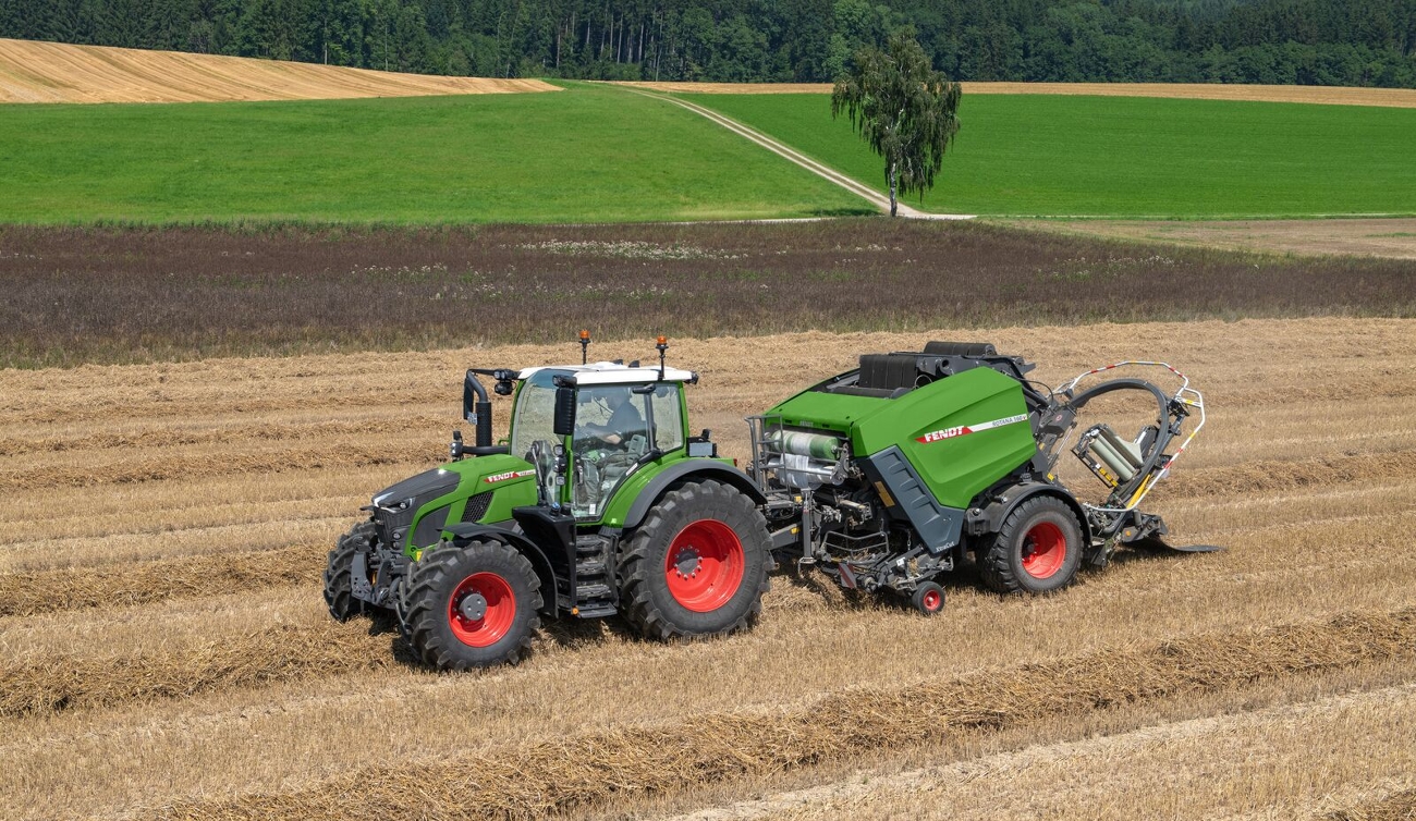 Fendt Rotana V Combi legt Ballen ab. Eine Fendt Rotana V Combi Rundballenpresse legt einen gewickelten Rundballen auf einem Feld ab.