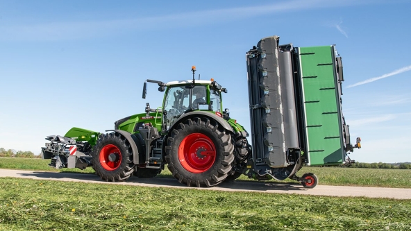 Fendt Traktor mit anliegendem Transporter auf einem Feldweg