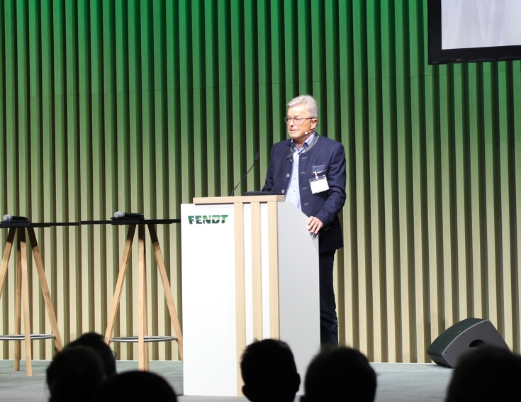 Dr. Heribert Reiter steht an einem Podium und spricht auf der Mitgliederversammlung des Fendt Classic Club International