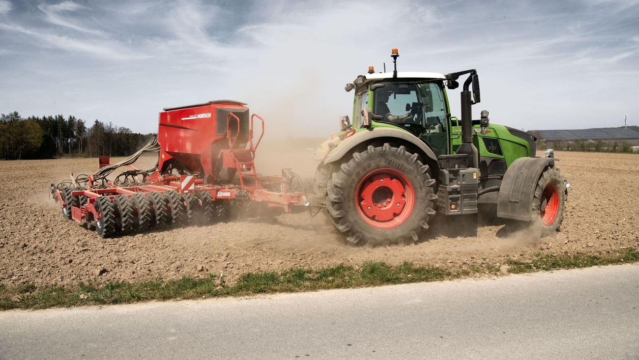 Fendt 700 Vario Ein Fendt 700 Vario mit Ladewagen fährt im Sommer auf einer Landstraße