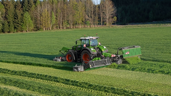 Fendt Traktor mit Heckmähwerk auf einer grünen Wiese aus der Vogelperspektive