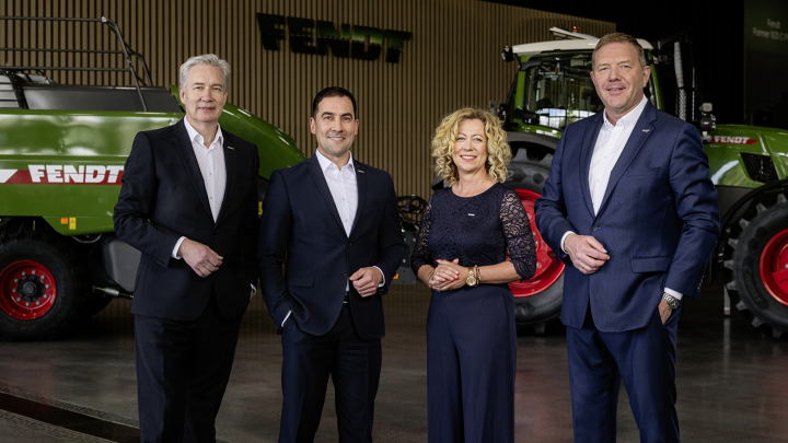 Die Geschäftsführung von Fendt Von links nach rechts stehen die Geschäftsführer Ekkehart Gläser, Dr. Josef Mayer, Ingrid Bußjäger-Martin und Christoph Gröblinghoff nebeneinander im Fendt Forum vor einem Fendt Traktor und der Fendt Quaderballenpresse