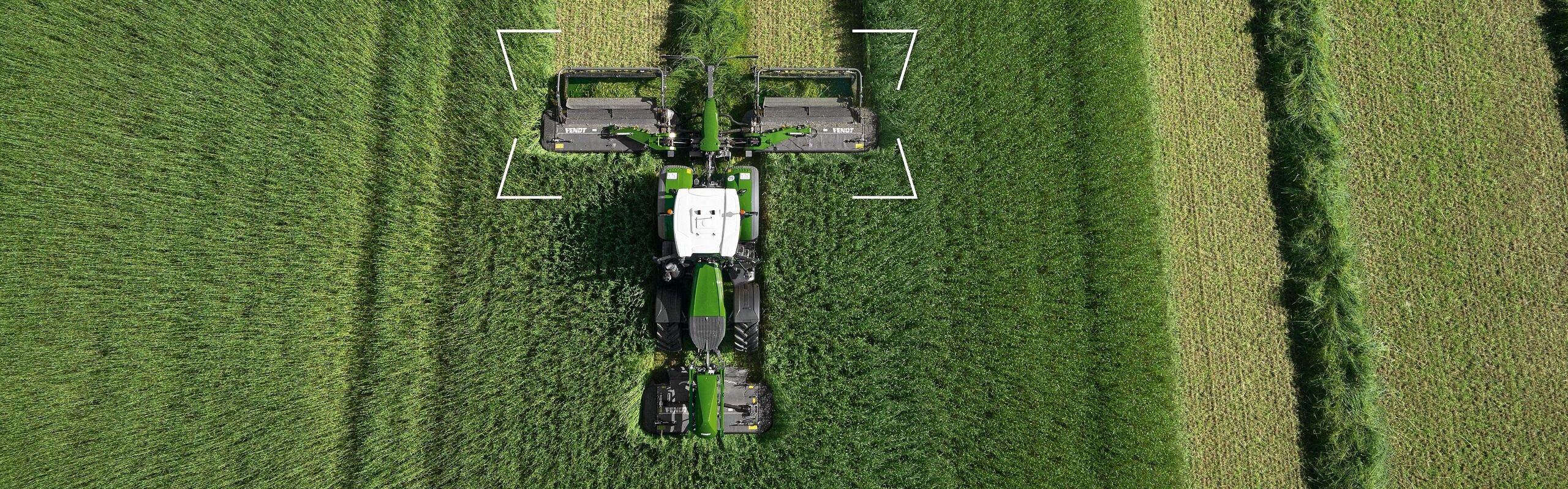 Feld, das gerade gemäht wird, aus der Vogelperspektive mit dem Fendt Faktor Fokus-Element auf dem Fendt Mähwerk