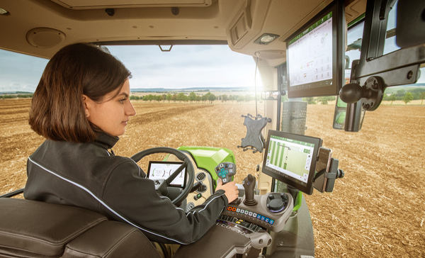 Fendt 700 Vario Gen7 med indbygget FendtONE En kvindelig landmand sidder i en Fendt 700 Vario Gen7 og kigger på terminalen.