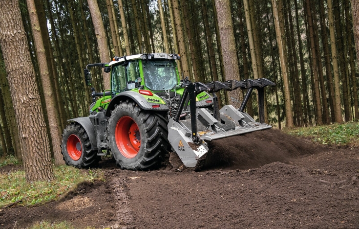 Fendt 700 Vario Gen7 med jordfræser i skoven En Fendt 700 Vario Gen7 med en jordfræser bagpå arbejder i en nåleskov