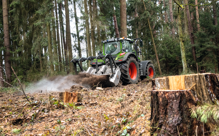 Fendt 700 Vario Gen7 med bagmonteret fræser En Fendt 700 Vario Gen7 fræser træstubbe i en nåleskov
