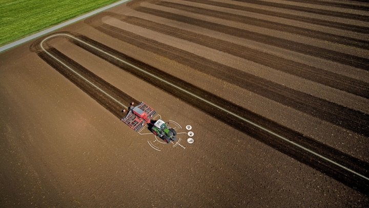 En traktor kører på en mark, hvor den præcise sporlinje kan ses.