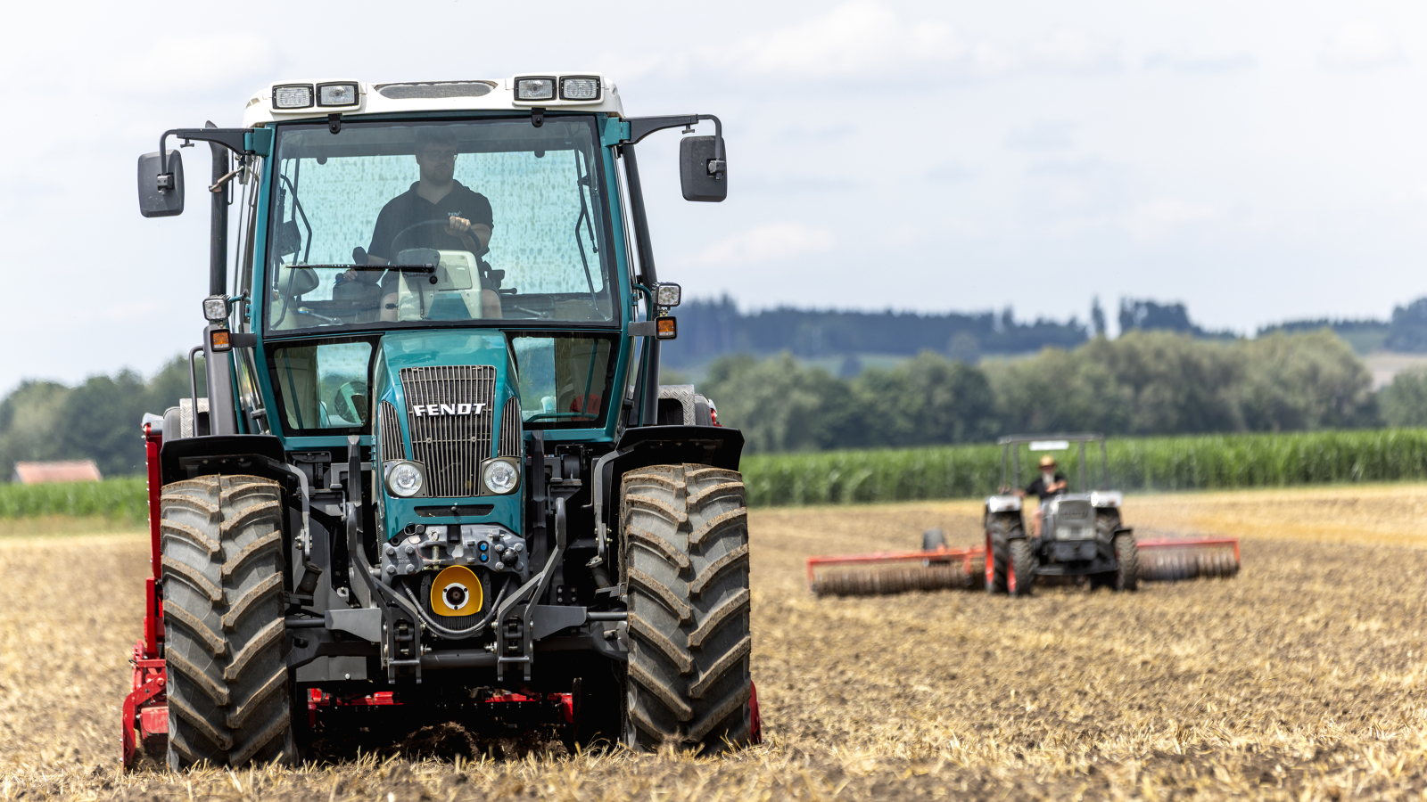 Fendt Evo En landmand kører med en blå Fendt Evo på en mark, ved siden af ham ses en Farmer 3 Hydrostat.