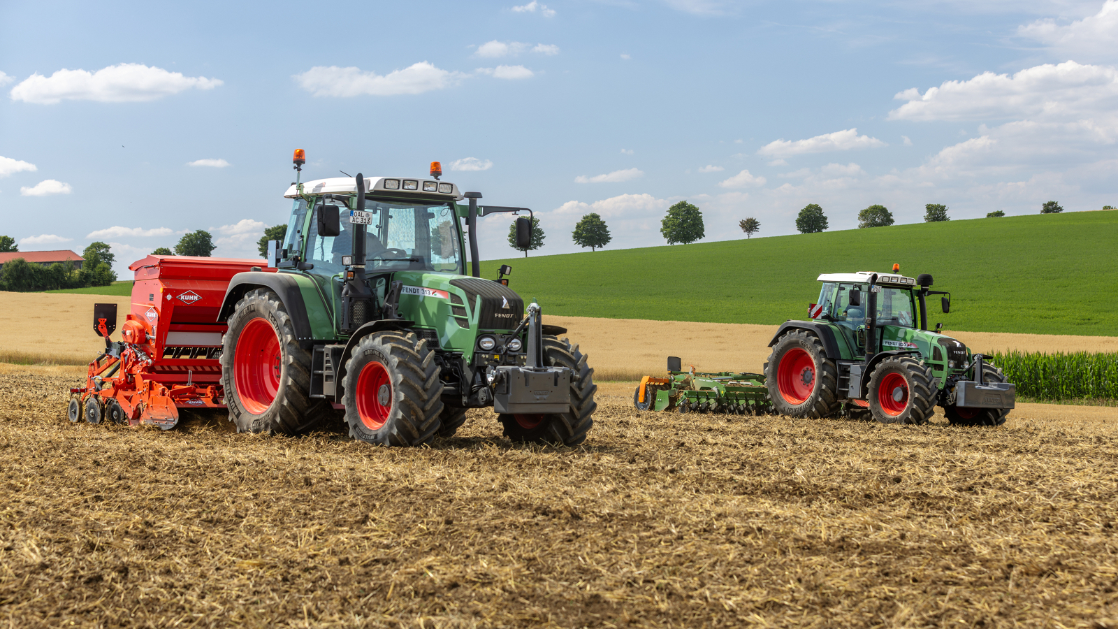 En landmand kører med en Fendt 300 Vario på en mark, i baggrunden ses en skov og en majsmark.