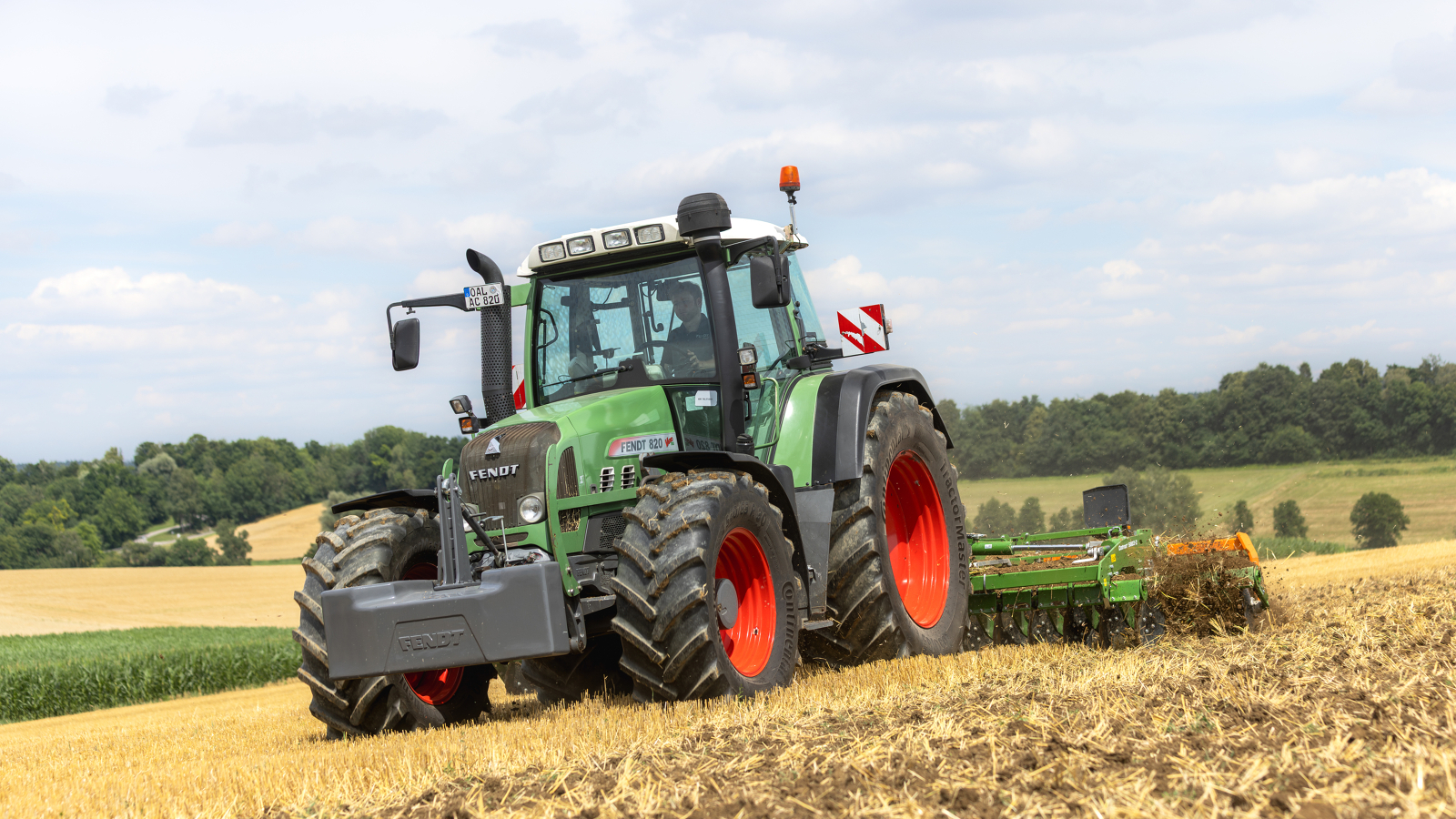 Fendt 820 Vario En landmand kører med en Fendt 820 Vario på marken, i baggrunden ses en træer