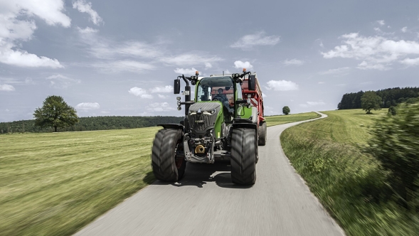 Fendt 700 Vario En Fendt 700 Vario med læssevogn kører på en landevej om sommeren