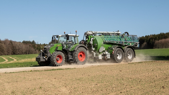 Fendt 724 Vario Gen7.1 med gyllevogn En grøn Fendt 724 Vario Gen7.1 fører en gyllevogn hen ad en grusvej.