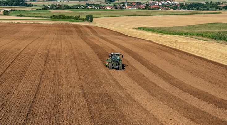 Fendt 500 Vario koos külvikombinatsiooniga põllul, vaade kaugelt.