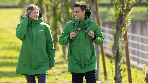 Fendt Jacket Leadership kollektsioonist Naine ja mees, kes kannavad rohelist Fendt Parker'i ja lähevad jalutuskäigule