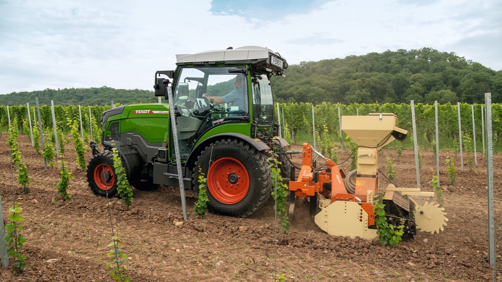 Fendt e100 V Vario sõidab puurmasinaga viinamäel