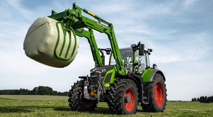 Fendt 600 Vario seisab põllul ja tõstab silopallid üles.