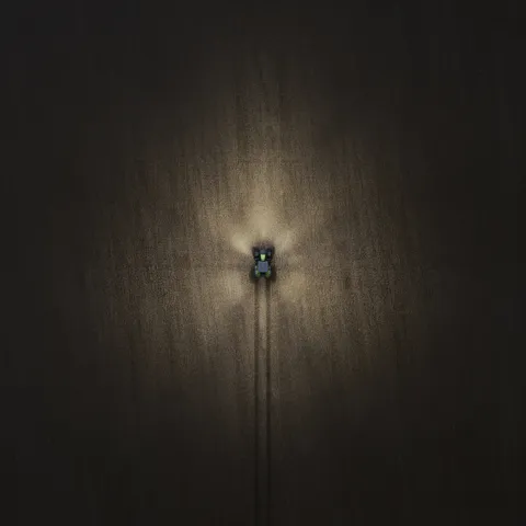 Imagen de dron de un Fendt 800 Vario de noche con las luces encendidas – 20%.