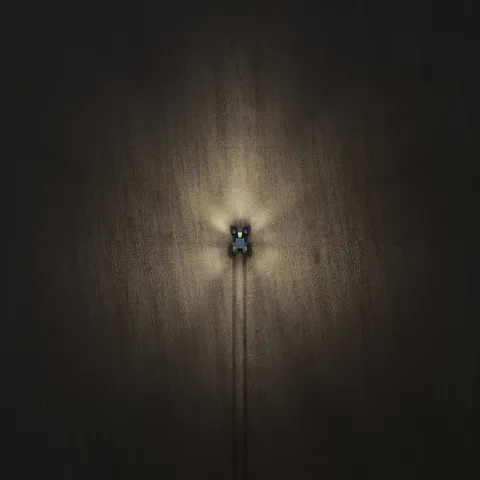 Imagen de dron de un Fendt 800 Vario de noche con las luces encendidas – 40%.