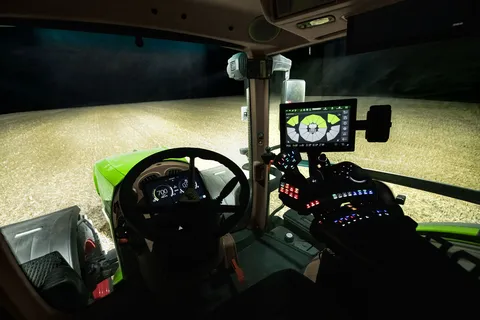 Vista desde la perspectiva del conductor del terminal en el reposabrazos con los mandos de iluminación del tractor