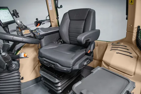 Vista del asiento de cuero del conductor en el interior de la cabina, con el reposabrazos detrás.