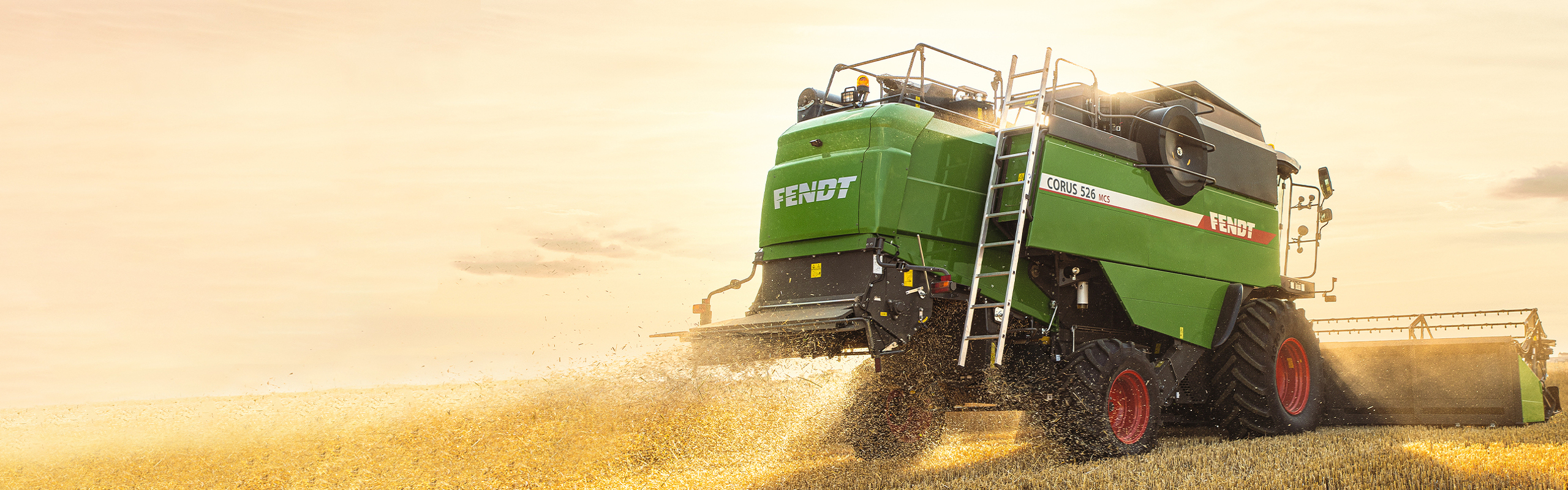 Un agricultor trillando con su cosechadora Fendt CORUS al anochecer.