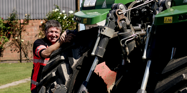 El agricultor Rob Buckle está rebosando de alegría delante de su máquina Fendt