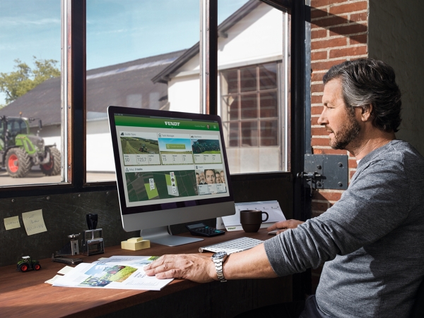 FendtONE Offboard y Onboard Un agricultor sentado en su oficina delante de un monitor con FendtONE offboard abierto.