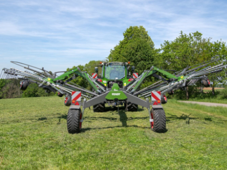 Un tractor parado en un prado con un rastrillo Fendt Former.