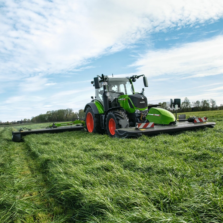 Un tractor Fendt circula con una Fendt Slicer frontal y una segadora trasera por el campo