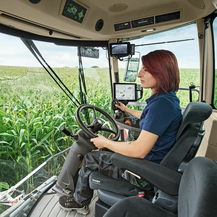 Una agricultora se sienta en su Fendt Katana y dirige la máquina a través de un campo de maíz.