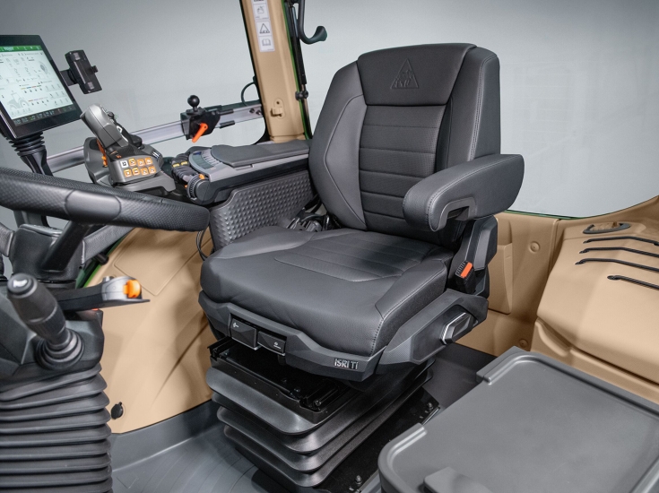 Asiento conductor Fendt Premium Vista del asiento de cuero del conductor en el interior de la cabina, con el reposabrazos detrás.