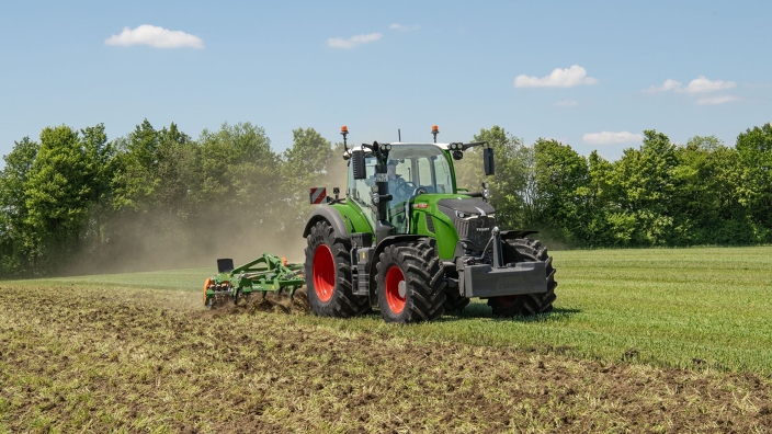Un Fendt 724 Vario Gen7.1 verde cavando un campo con un cultivador Amazone.