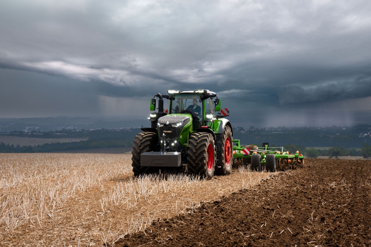 El tractor Fendt 1000 Vario sigue realizando con brío su trabajo en el campo frente a las pesadas nubes de tormenta que se ciernen a lo lejos