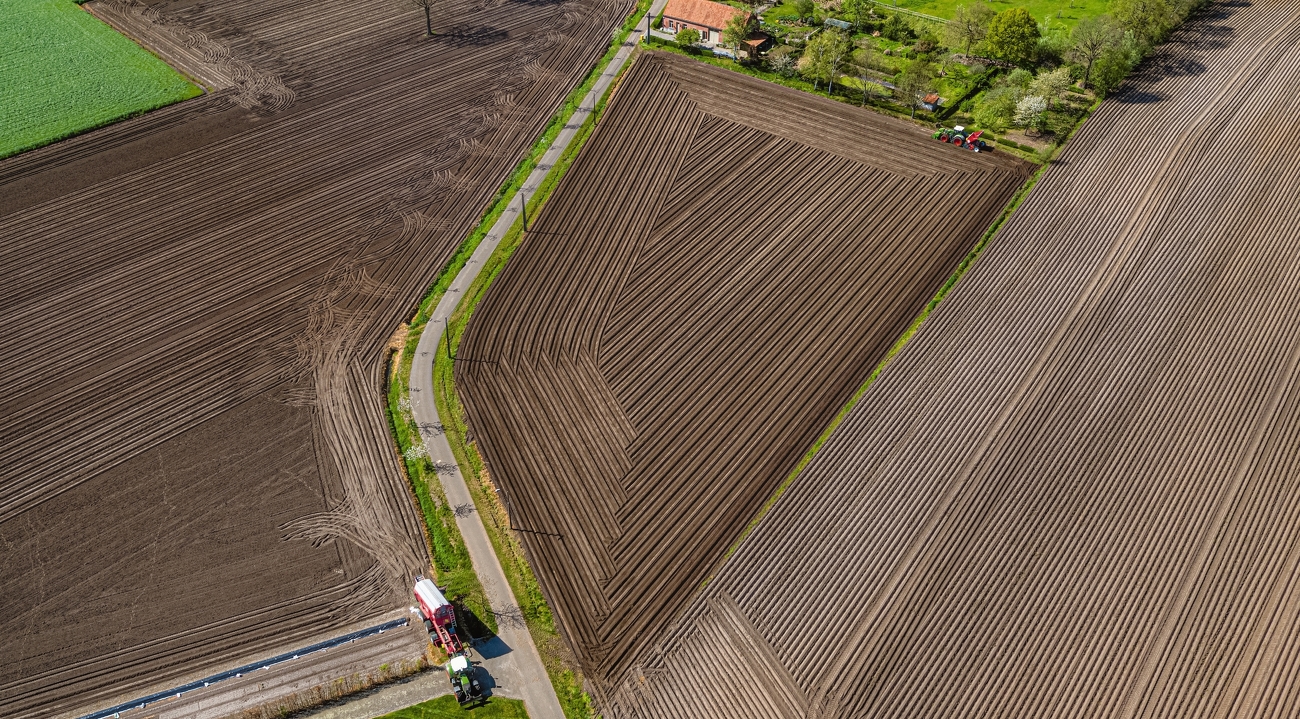 Fendt Vario ajaa peltoa alaspäin, lintuperspektiivistä on nähtävissä valmiiksi automaattiohjauksella työstetyt pellot.