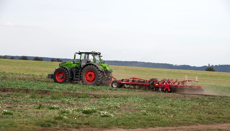 Vihreä Fendt 1000 Vario -traktori muokkaa peltoa punaisella Horsch-kultivaattorilla väliviljelypellolla.