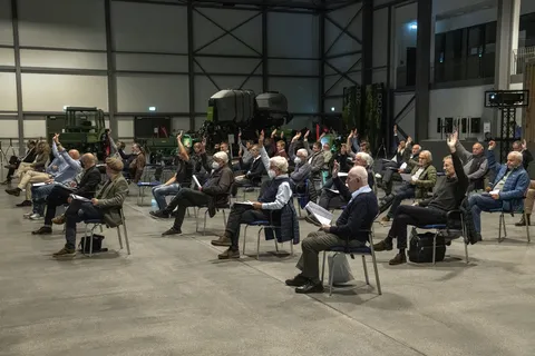 Le public lors de la création du Fendt Classic Club International dans le hall du Fendt Forum, avec différentes machines Fendt en arrière-plan. Une partie du public a levé les mains.