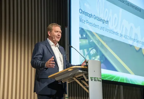 Christoph Gröblinghoff se tient devant une image projetée d'une présentation Fendt, derrière un pupitre portant le logo Fendt, et prononce un discours.