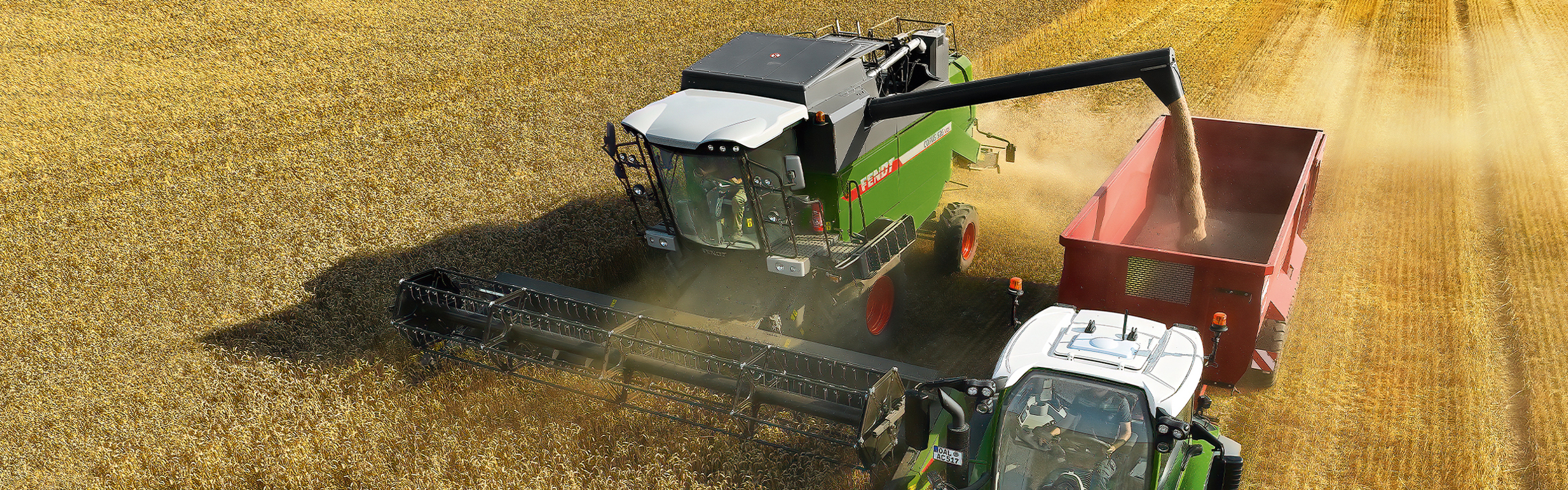 Un Fendt CORUS et un tracteur Fendt avec benne basculante en plein battage.