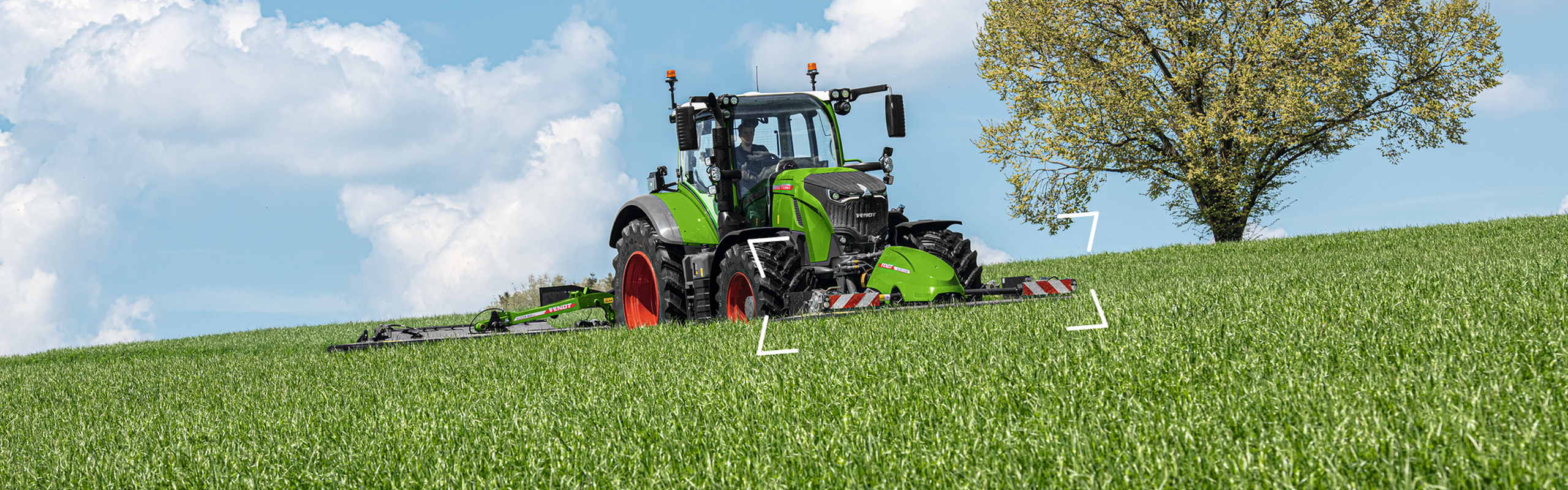 Un tracteur Fendt vert équipé d'une combinaison de faucheuses Slicer pendant la récolte des prairies
