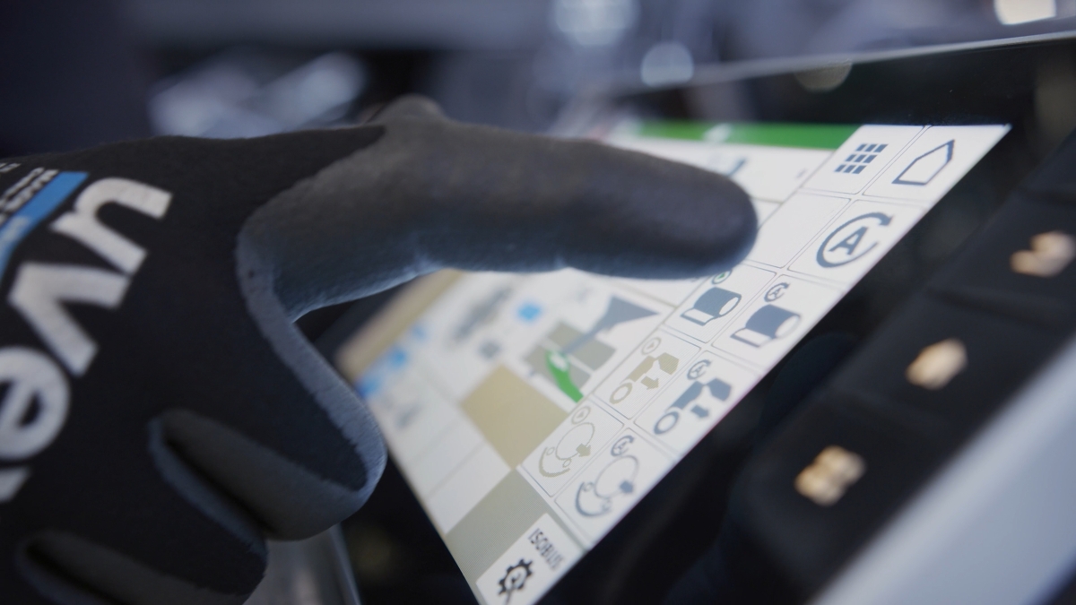 Un employé Fendt porte des gants et tape sur un écran.