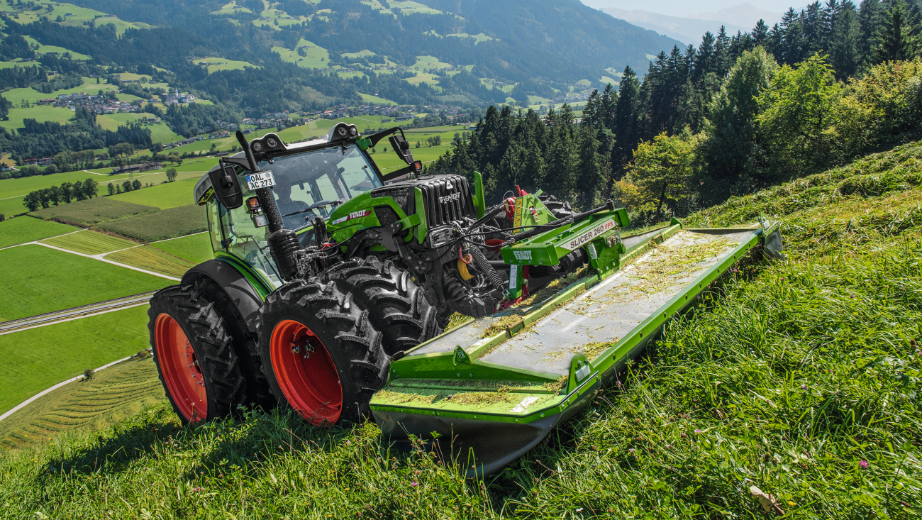 Un agriculteur fauche une pente avec une faucheuse frontale Fendt Slicer.