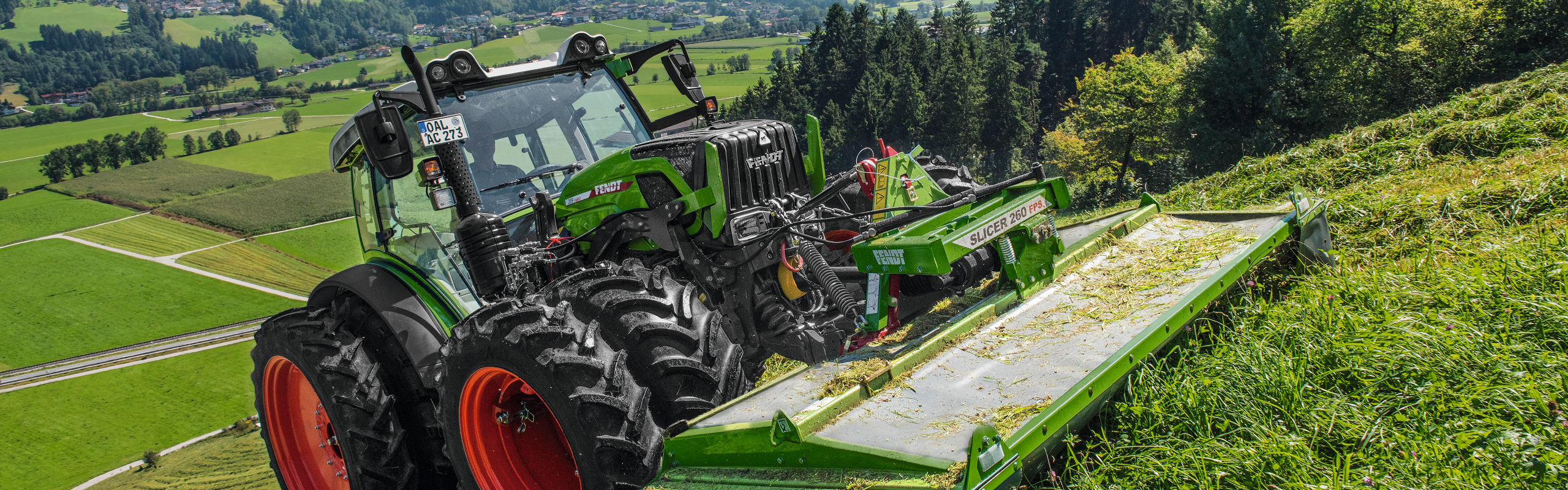 Fendt Slicer 260 FPS en action sur une pente dans une prairie.