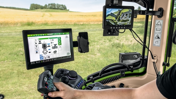 Le terminal du tracteur est montré dans une cabine de conduite, sur laquelle on peut voir le menu pour la presse à balles.