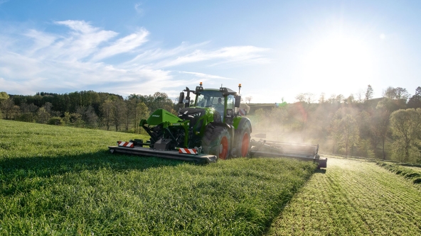 Tracteur Fendt avec faucheuse frontale et arrière dans la prairie