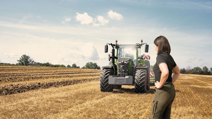 Fendt 700 Vario Gen7 Une agricultrice se tient dans un champ de chaumes devant son Fendt 700 Vario Gen7.