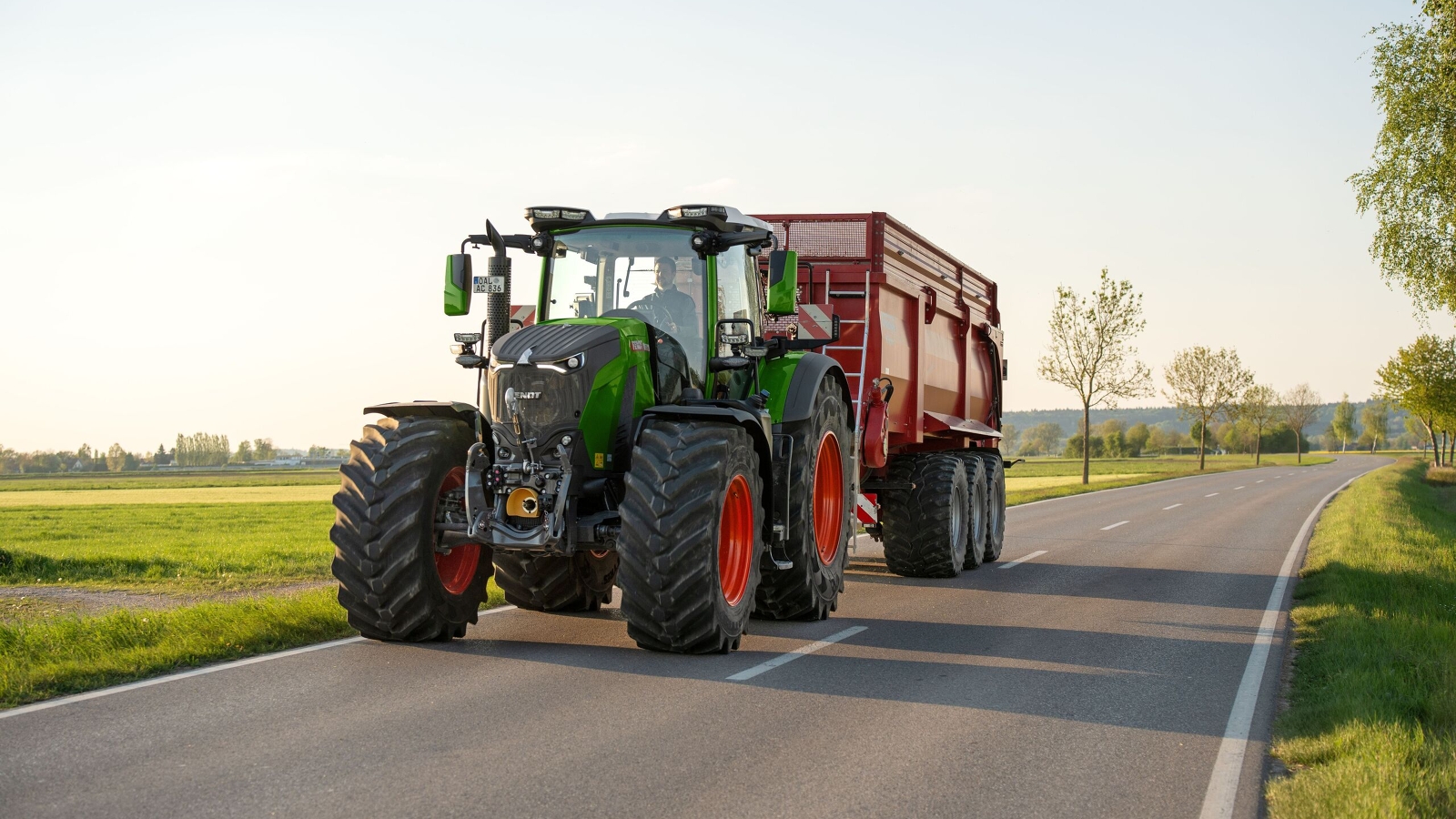 Egy Fendt 800 Vario függesztett rendfelszedő pótkocsival egy földúton